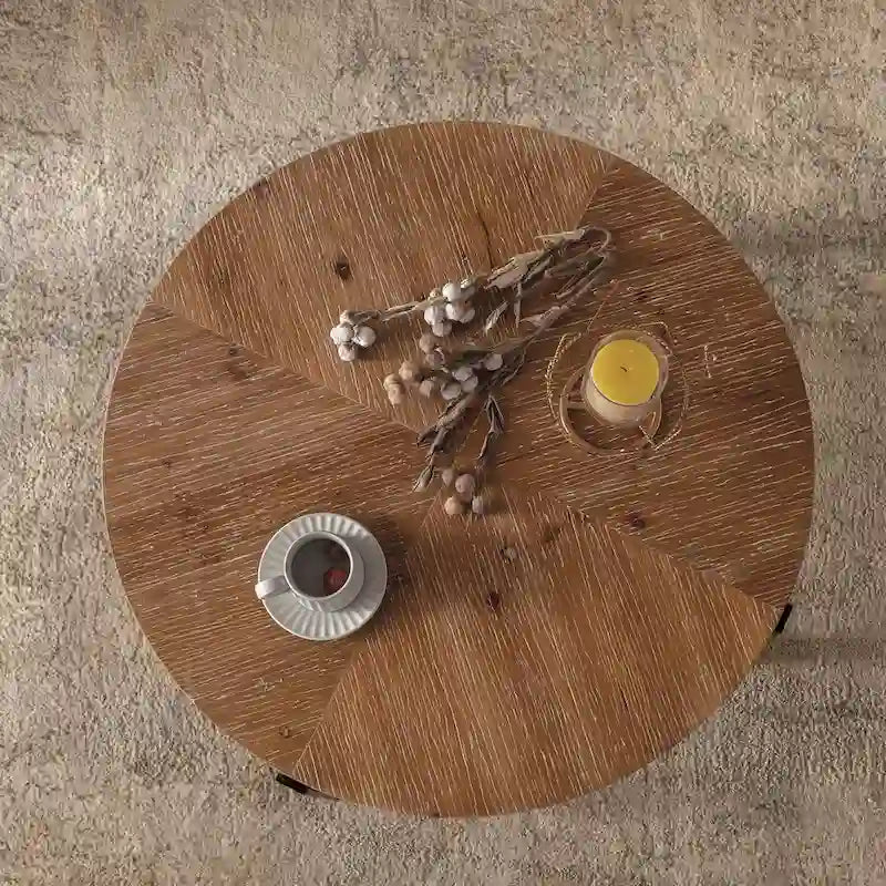 Table basse ronde moderne rétro avec plateau en bois de sapin et piètement croisé noir, idéale pour le salon.