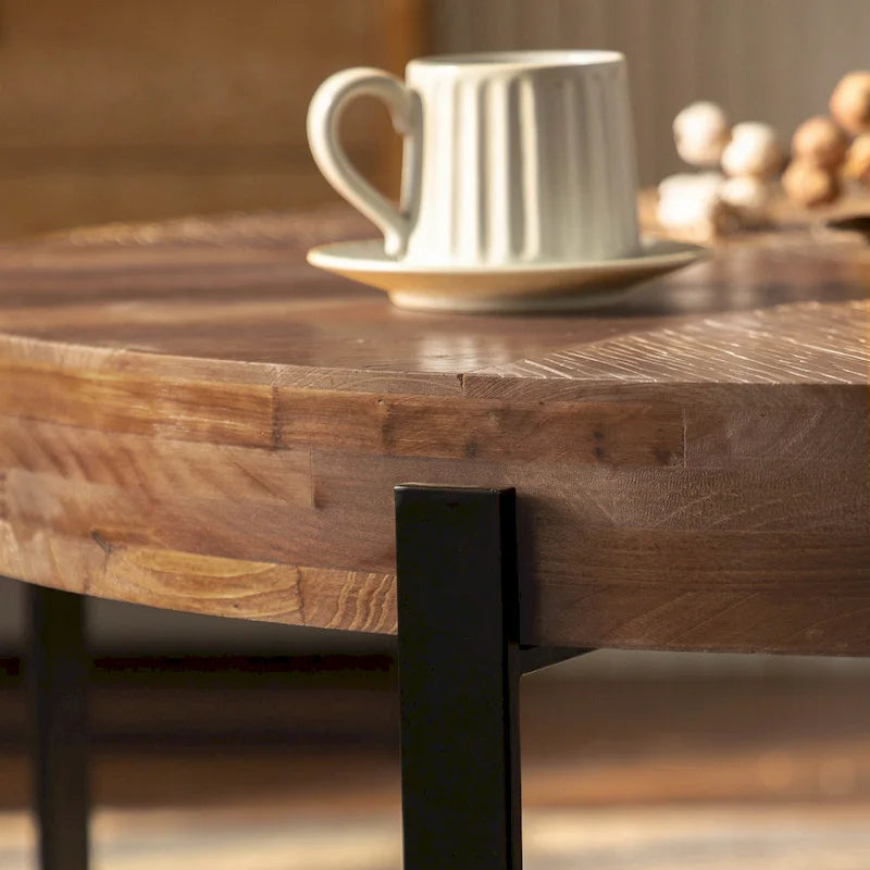 Table basse ronde moderne rétro avec plateau en bois de sapin et piètement croisé noir, idéale pour le salon.