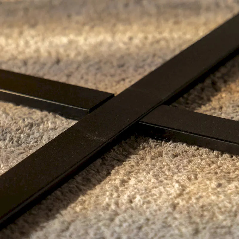 Table basse ronde moderne rétro avec plateau en bois de sapin et piètement croisé noir, idéale pour le salon.
