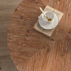 Table basse ronde moderne rétro avec plateau en bois de sapin et piètement croisé noir, idéale pour le salon.