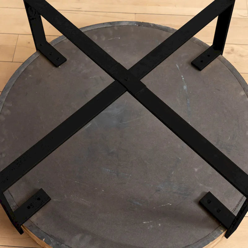 Table basse ronde moderne rétro avec plateau en bois de sapin et piètement croisé noir, idéale pour le salon.