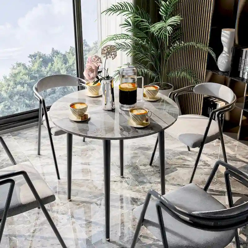 Table de salle à manger ronde avec plateau en marbre et pieds en métal, idéale pour la salle à manger ou la cuisine.